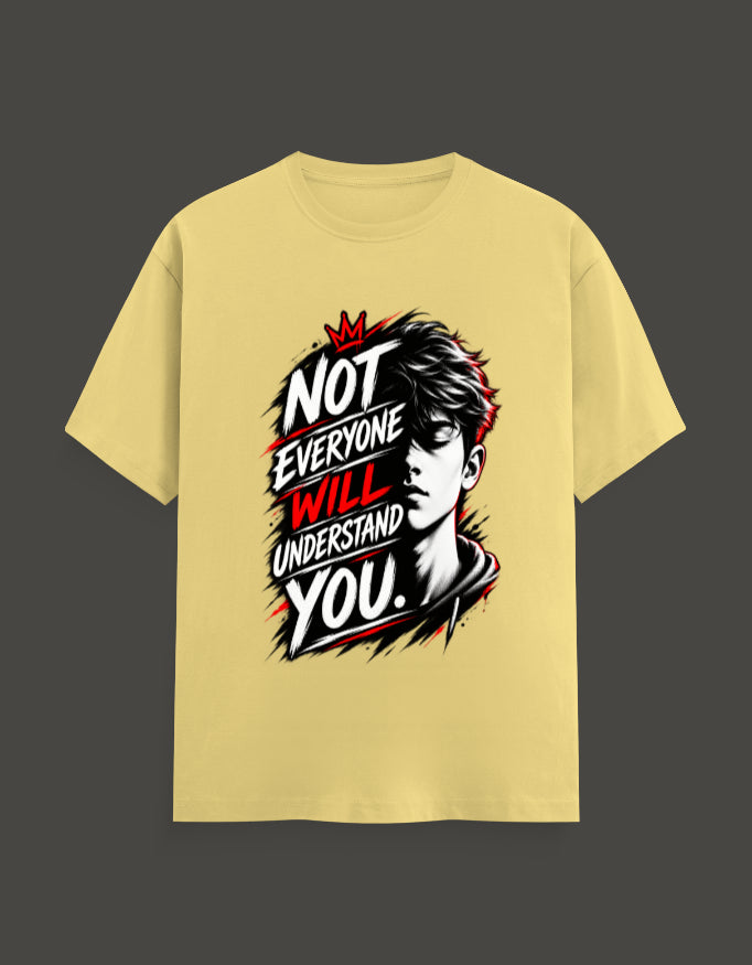 A pale yellow short-sleeve t-shirt with a graphic print on the front. The graphic features a stylized black and white portrait of a man's face layered with bold text that reads 'NOT EVERYONE WILL UNDERSTAND YOU.